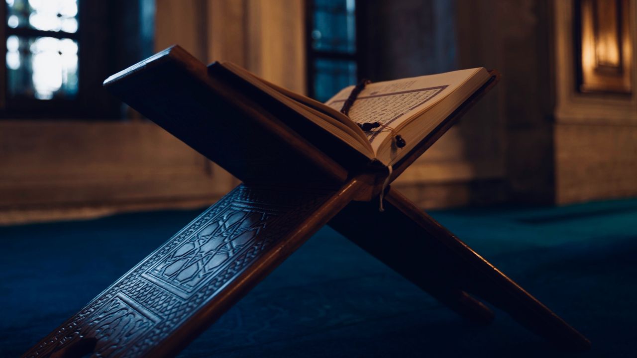 A Quran resting on a wooden stand inside a mosque in Istanbul, captured in soft lighting.